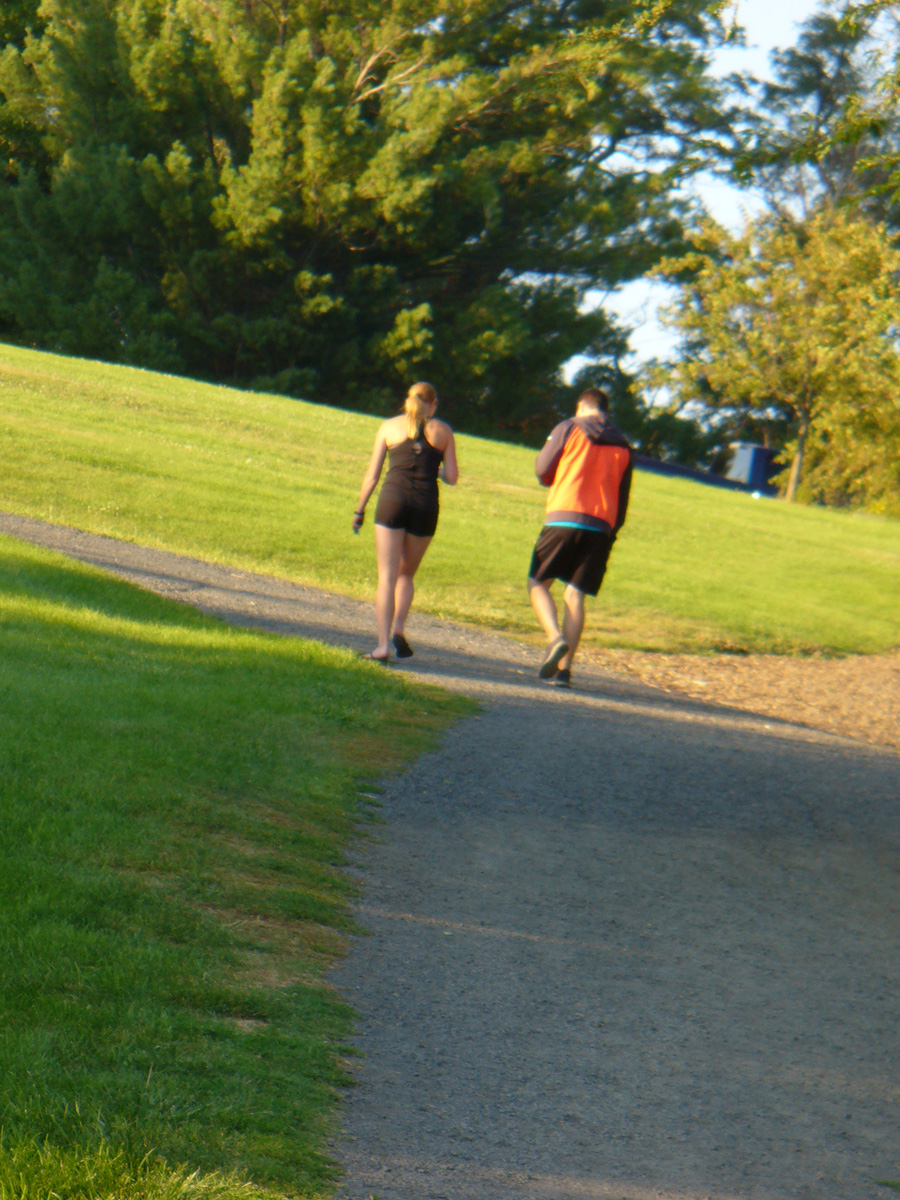 Two people walking in park by Susan Fluegel